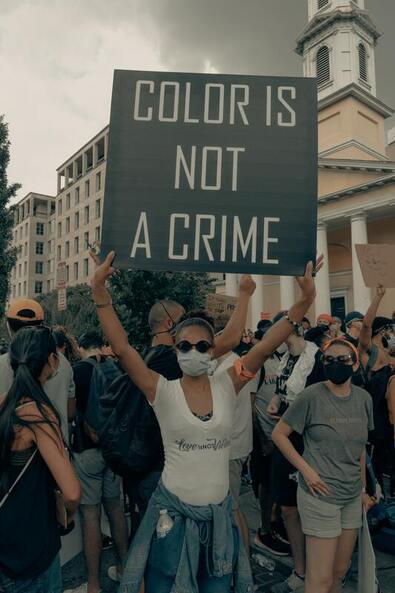A protestor with a sign saying color is not a crime